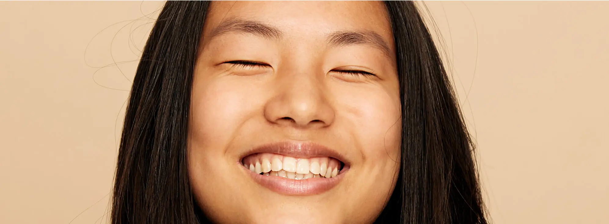 Une femme heureuse qui sourit les yeux fermés